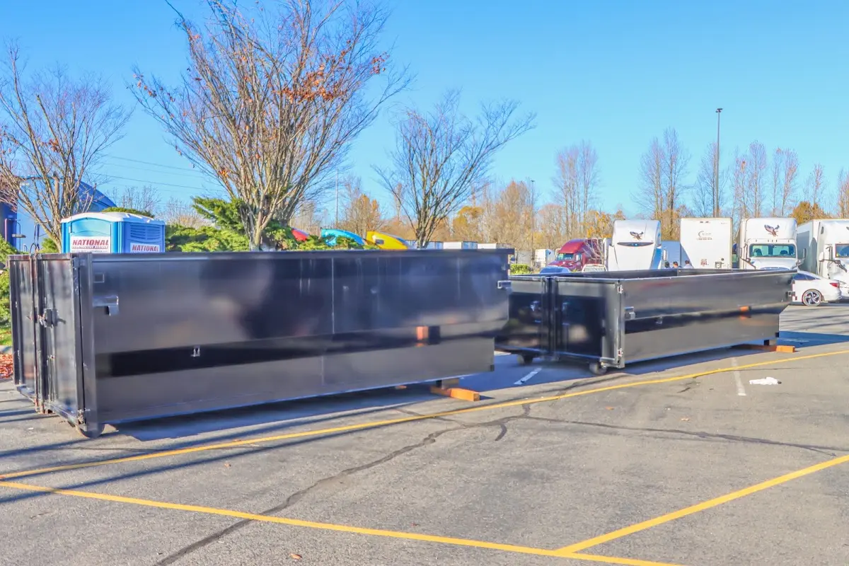 Professional dumpster rental service with roll-off container on residential driveway in Robeson